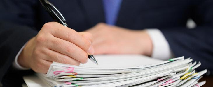 Lawyer signing a stack of papers